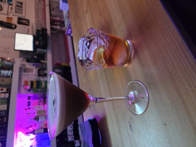 an espresso martini and an Old Fashioned sit on a wood bar at Bar Lido in Cordoba 