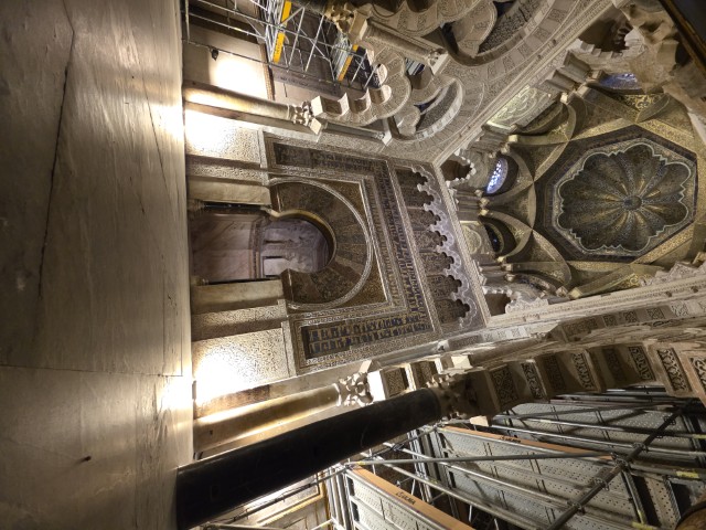 The Mihrab of the Mezquita-Catedral in Córdoba Spain, an ornately decorated prayer niche with intricate geometric mosaics, horseshoe arch, and octagonal scallop shell dome dating to the 10th century