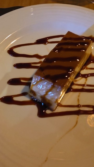 a slice of Spanish flan with caramel sauce drizzled on top. 