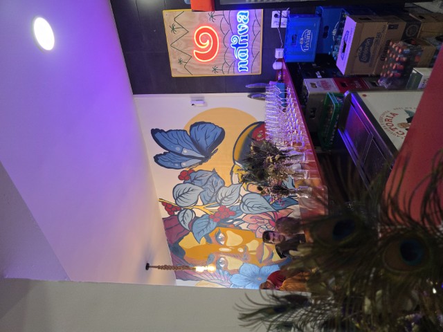 Inside wall of Nativa Gastrobar. There is a large mural of a womans face wiht butterflies and flowers