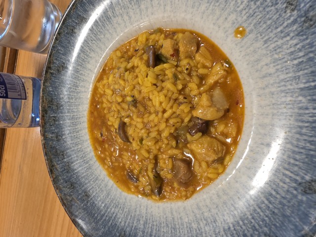 A blue and gray bowl with a dish of rice and mushrooms. 