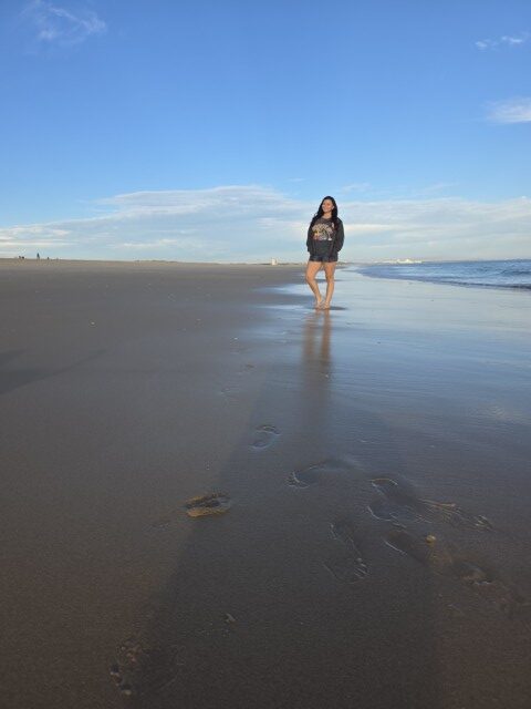  Woman standing on a wide sandy beach in the Algarve Portugal