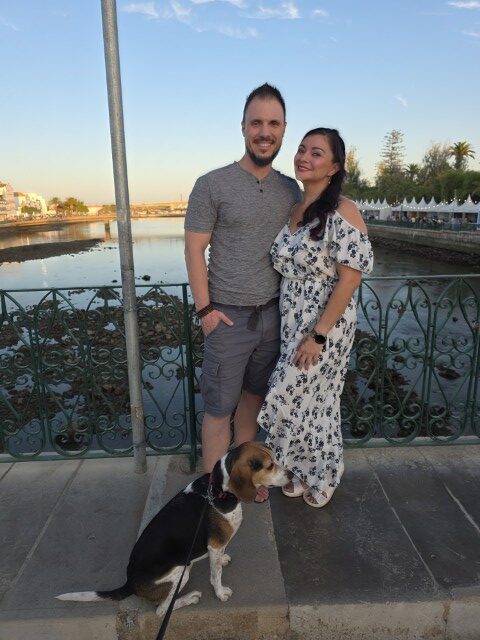 Couple and their beagle posing on the Roman Bridge in Tavira Portugal at sunset